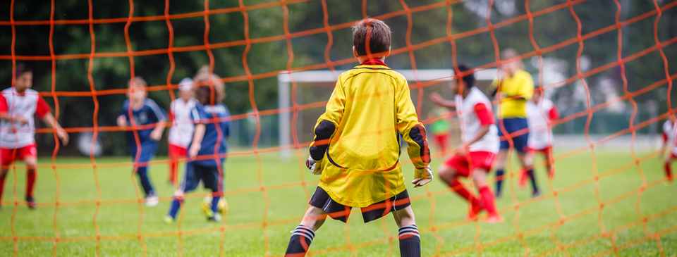 Small yellow football goals on a stadium field during autumn